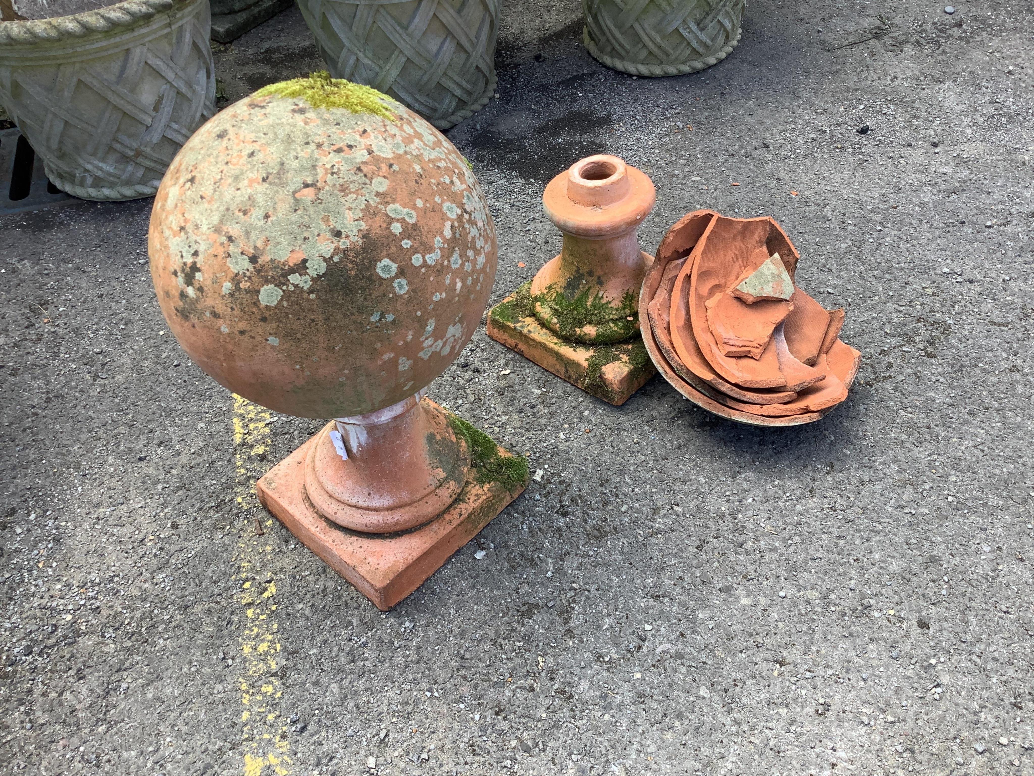 A large pair of weathered terracotta sphere garden ornaments, one in need of restoration, height 58cm. Condition - one good, one poor